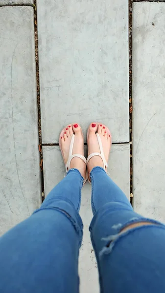 コンクリートの摩耗サンダルを女性の足にクローズ アップ — ストック写真