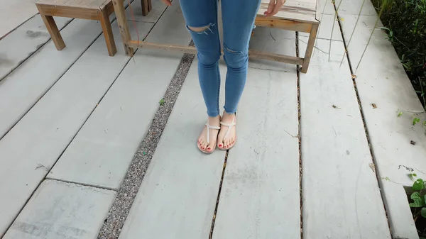 Mulher vestindo sandálias no chão de concreto — Fotografia de Stock