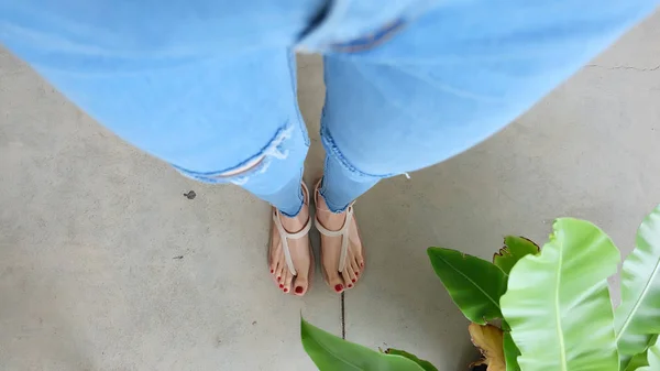 De cerca en los pies de la mujer Usar sandalias en el hormigón —  Fotos de Stock