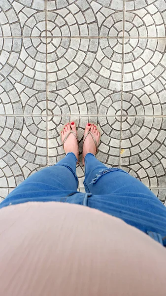 Ayak Selfie döşeme arka planı üzerinde duran altın sandaletler içinde