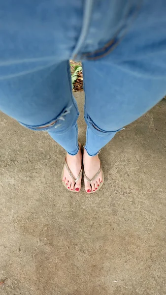 Frau trägt Sandalen auf dem Betonboden — Stockfoto