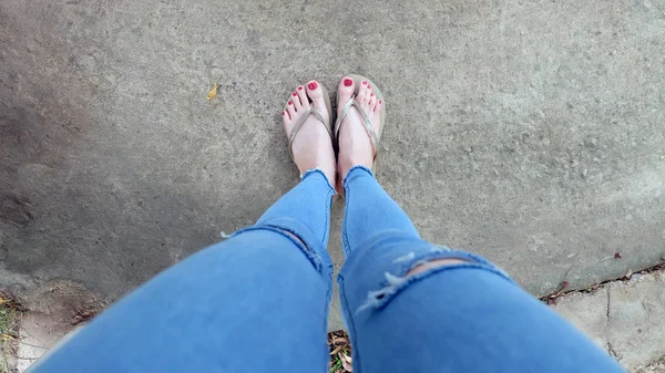 Beton zemin üzerinde sandalet giyen kadın