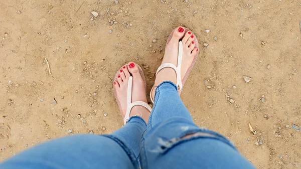 Close Up on Girl 's Feet vestindo sandálias e unhas vermelhas no solo fundo — Fotografia de Stock