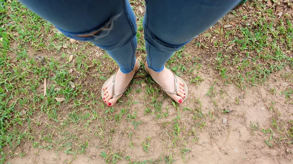 Pieds Selfie dans des sandales en or debout sur fond d'herbe verte — Photo