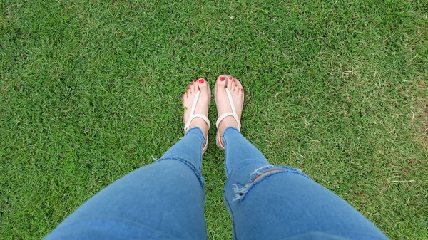站在绿草背景上的金凉鞋中的脚自拍 — 图库照片