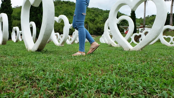 Fötter Selfie i sandaler står på grönt gräs med vitt hjärta form konstgjorda bakgrund — Stockfoto