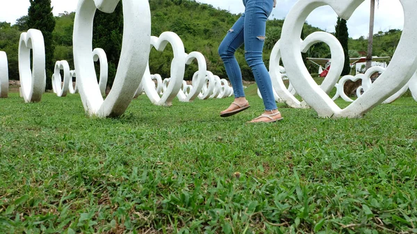 Pieds Selfie dans des sandales debout sur herbe verte avec fond artificiel en forme de coeur blanc — Photo