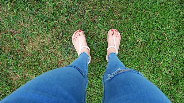 Selfie stopy w złocie sandały, stojąc na tle zielonej trawie — Zdjęcie stockowe