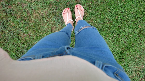 Füße-Selfie in goldenen Sandalen auf grünem Gras-Hintergrund — Stockfoto