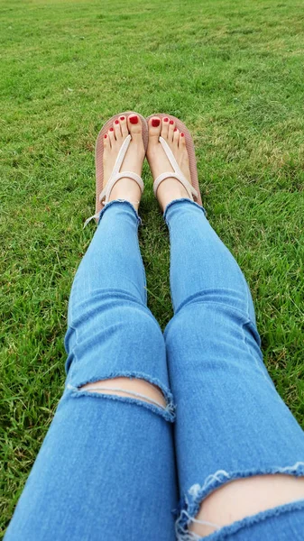 Pieds Selfie dans des sandales en or debout sur fond d'herbe verte — Photo