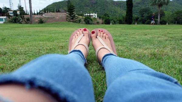 Feet Selfie in Gold Sandals Standing on Green Grass Background