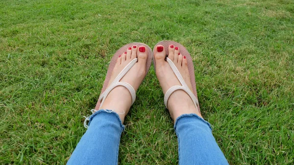 Fötter Selfie i guld sandaler står på grönt gräs bakgrund — Stockfoto
