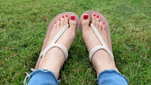 Selfie de pies en sandalias de oro de pie sobre fondo de hierba verde — Foto de Stock