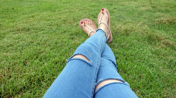 Selfie de pies en sandalias de oro de pie sobre fondo de hierba verde — Foto de Stock