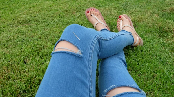 Füße-Selfie in goldenen Sandalen auf grünem Gras-Hintergrund — Stockfoto