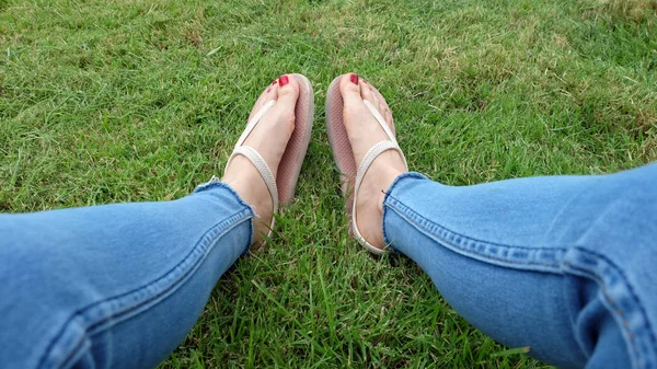 Pieds Selfie dans des sandales en or debout sur fond d'herbe verte — Photo