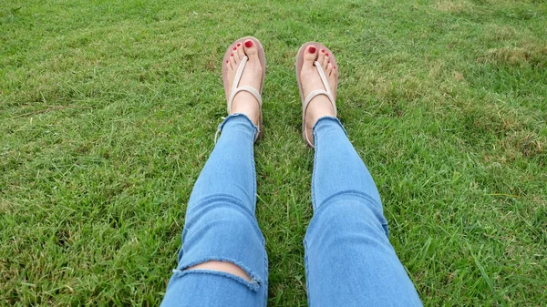 Füße-Selfie in goldenen Sandalen auf grünem Gras-Hintergrund — Stockfoto