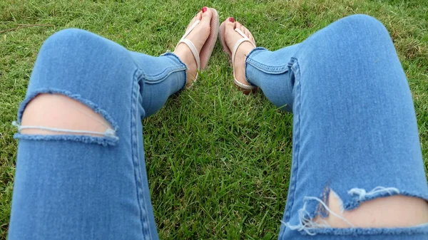 Füße-Selfie in goldenen Sandalen auf grünem Gras-Hintergrund — Stockfoto