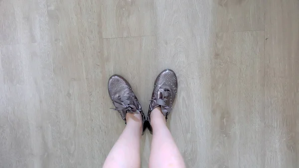 Selfie de pies en zapatillas marrones de pie sobre un fondo de piso de madera — Foto de Stock