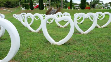 Çimento beyaz kalp şekli suni, çim yeşil arka plan üzerine Inşa