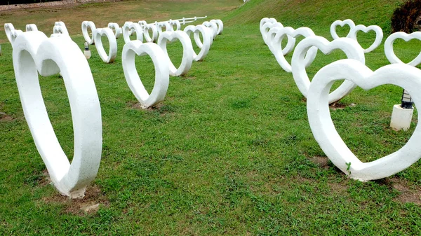 Cemento en forma de corazón blanco artificial, construido sobre hierba fondo verde — Foto de Stock