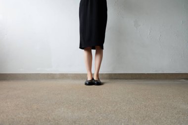 İnce bacakları kadın giyim siyah elbise ve siyah sokak arka plan üzerinde ayakkabı