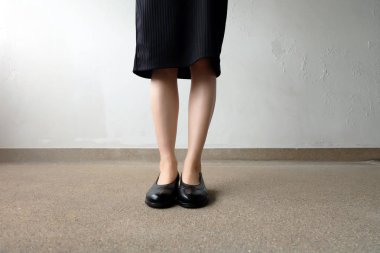 İnce bacakları kadın giyim siyah elbise ve siyah sokak arka plan üzerinde ayakkabı