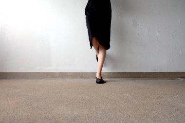 İnce bacakları kadın giyim siyah elbise ve siyah sokak arka plan üzerinde ayakkabı