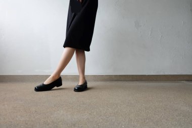 İnce bacakları kadın giyim siyah elbise ve siyah sokak arka plan üzerinde ayakkabı