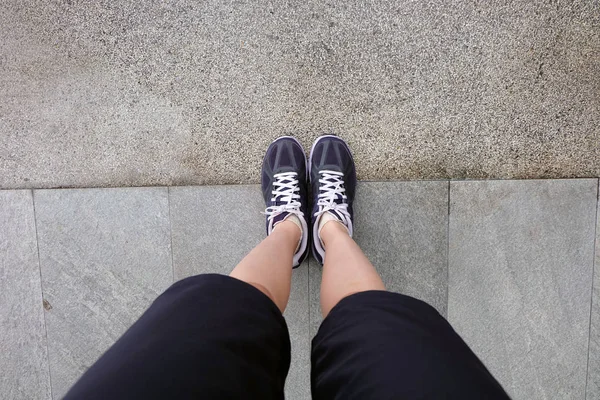 Sport violette Turnschuhe, junge Frau mit Laufschuhen auf dem Zementhintergrund — Stockfoto