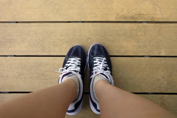 Jovem mulher de correr sapatos no chão de madeira fundo, esporte violeta tênis conceito — Fotografia de Stock