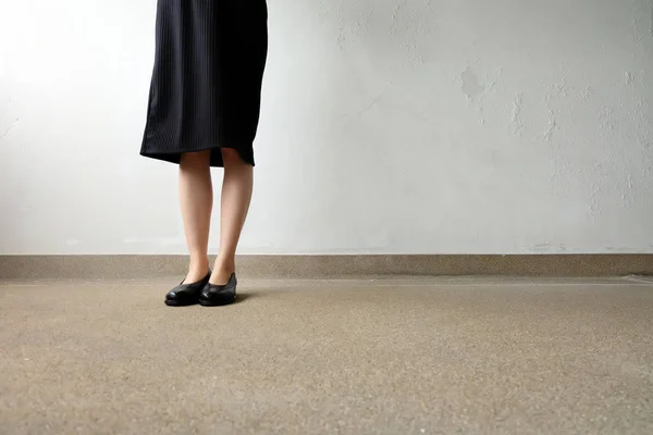 Pernas finas mulher usar vestido preto e sapatos pretos no fundo da rua — Fotografia de Stock