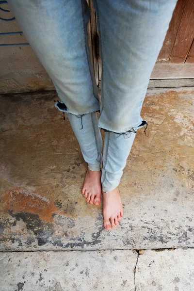 Selfie a piedi nudi Indossare Blue Jeans su sfondo vecchio cemento — Foto Stock