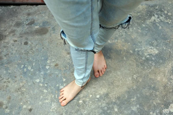 Selfie a piedi nudi Indossare Blue Jeans su sfondo vecchio cemento — Foto Stock