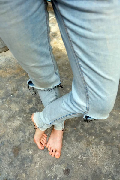 Селфи босиком носит синие джинсы на старом бетонном фоне — стоковое фото