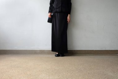 Yas ayak erkek siyah düz ayakkabı ve beton zemin üzerine duran siyah elbise