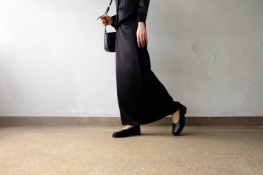 Yas ayak erkek siyah düz ayakkabı ve beton zemin üzerine duran siyah elbise