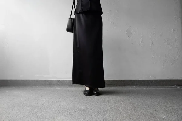 Mourning Feet Female in Black Flat Shoes and Black Dress Standing on the Concrete Background — Stock Photo, Image