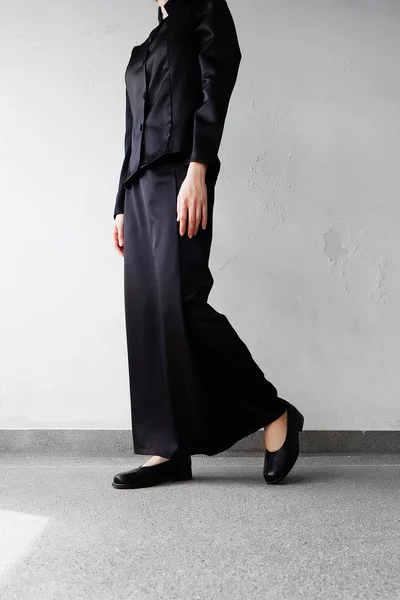 Mourning Feet Female in Black Flat Shoes and Black Dress Standing on the Concrete Background — Stock Photo, Image