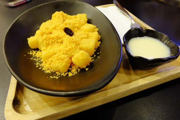 Lezzetli Kızarmış peynirli çubuk ahşap plaka arka plan arka plan üzerinde şekerli yoğunlaştırılmış süt ile tedavi