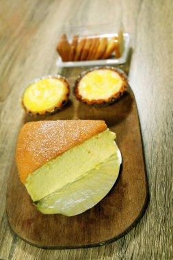 Taze yumurta Tart ve tereyağı pasta, ahşap masa arka plan üzerinde izole yumuşak pasta dilimi