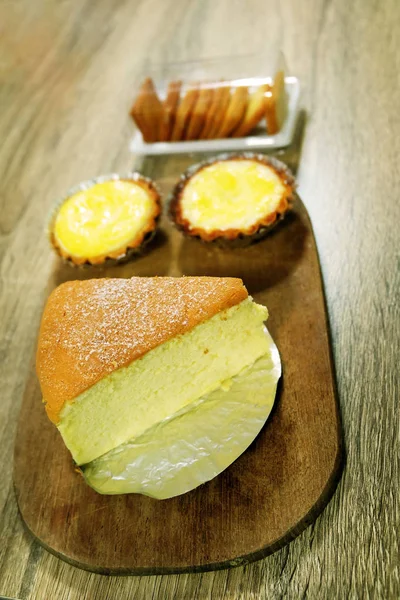 Torta de ovo fresco e bolo de manteiga, fatia de bolo macio isolado no fundo da mesa de madeira — Fotografia de Stock