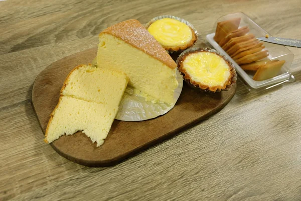 新鲜蛋馅饼和黄油蛋糕, 在木桌背景上分离的软蛋糕片 — 图库照片