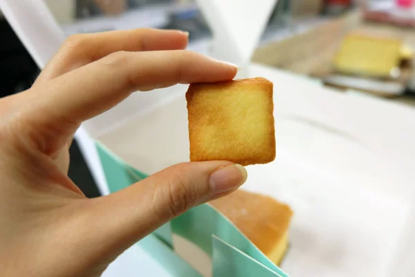 Close Up Square Bread, Hand hold Crackers on Box Cake Background