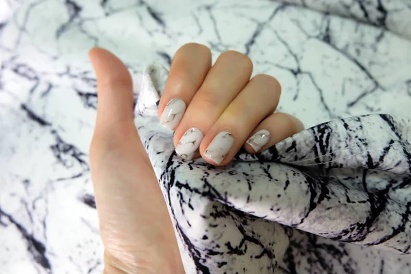 Hermoso esmalte de uñas, clavo de manicura. Cerca de uñas de granito gris en la tela de piedra de granito —  Fotos de Stock