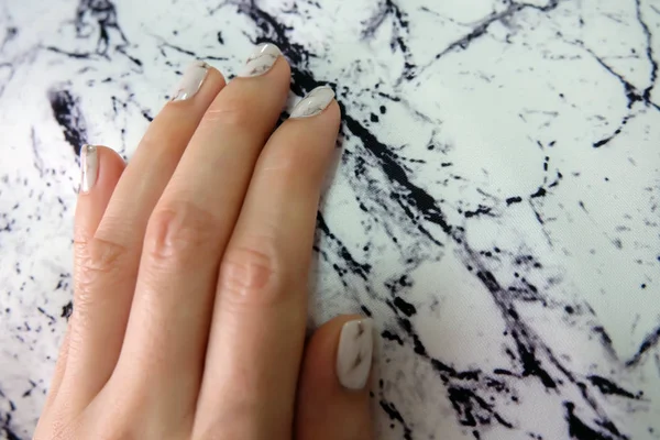 Hermoso esmalte de uñas, clavo de manicura. Cerca de uñas de granito gris en la tela de piedra de granito —  Fotos de Stock