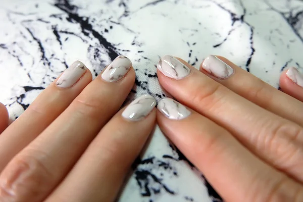 Bellissimo Smalto, Unghie Manicure. Chiodi grigio granito da vicino sul tessuto di pietra di granito — Foto Stock