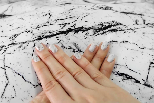 Hermoso esmalte de uñas, clavo de manicura. Cerca de uñas de granito gris en la tela de piedra de granito — Foto de Stock