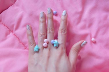 Granit gri çivi. Pembe battaniye arka plan üzerinde renkli boncuk boyasıyla çivi kadar kapatın