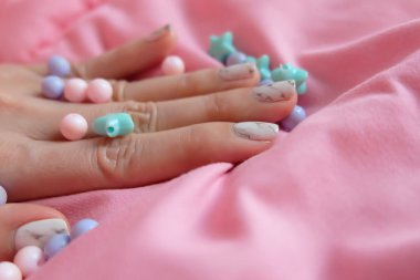 Granit gri çivi. Pembe battaniye arka plan üzerinde renkli boncuk boyasıyla çivi kadar kapatın